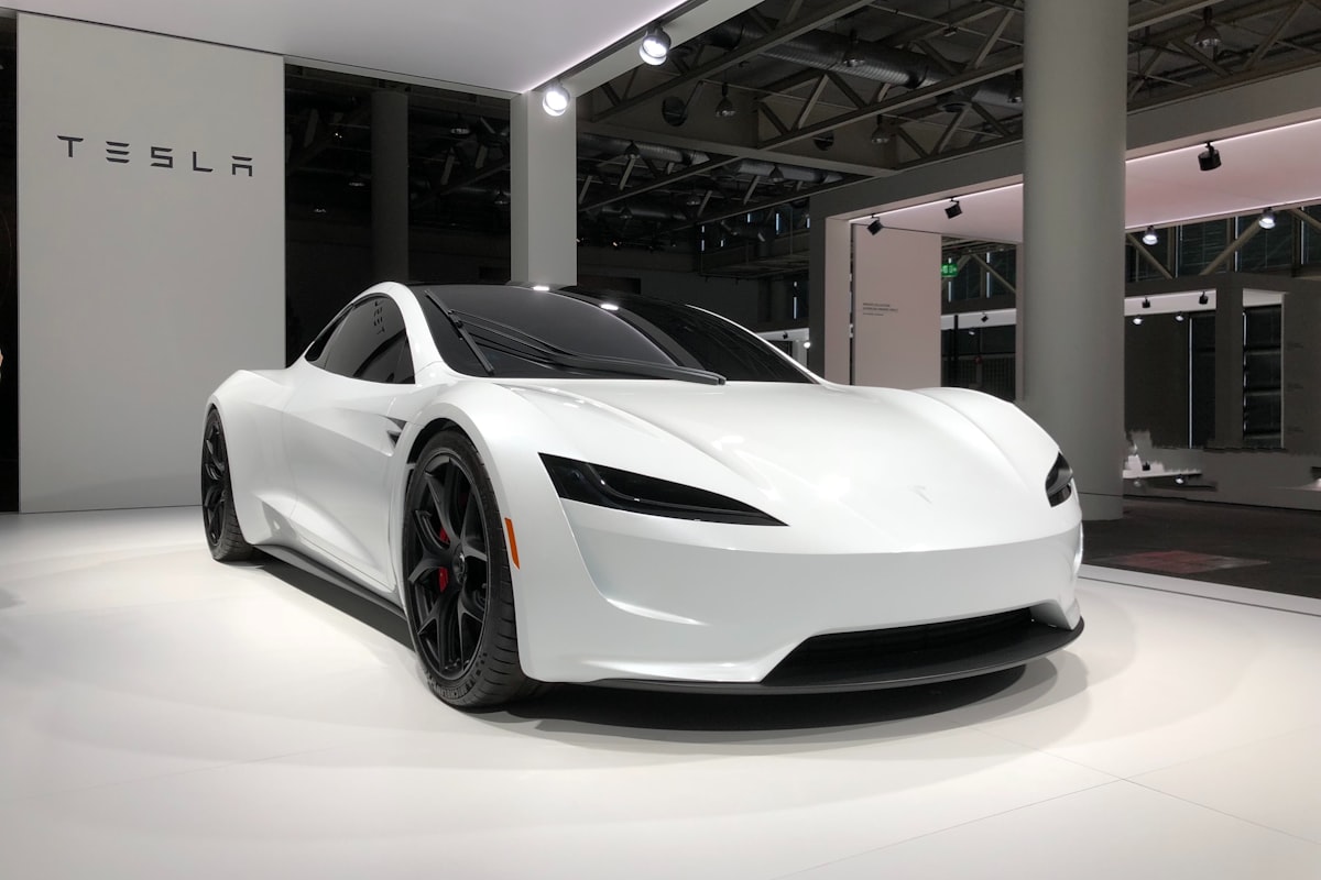 White electric sports car on display in a showroom, illustrating modern electrified vehicles